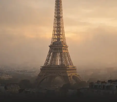 The Eiffel Tower rising over Paris in golden mist